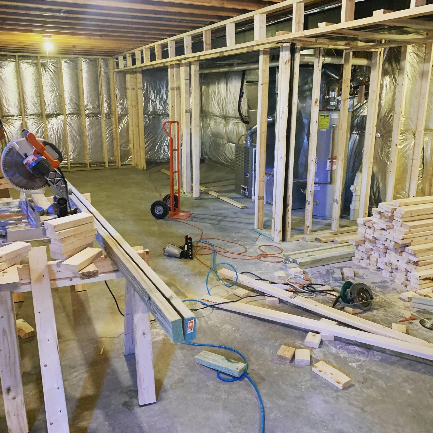 A room with a lot of wood and a circular saw in it