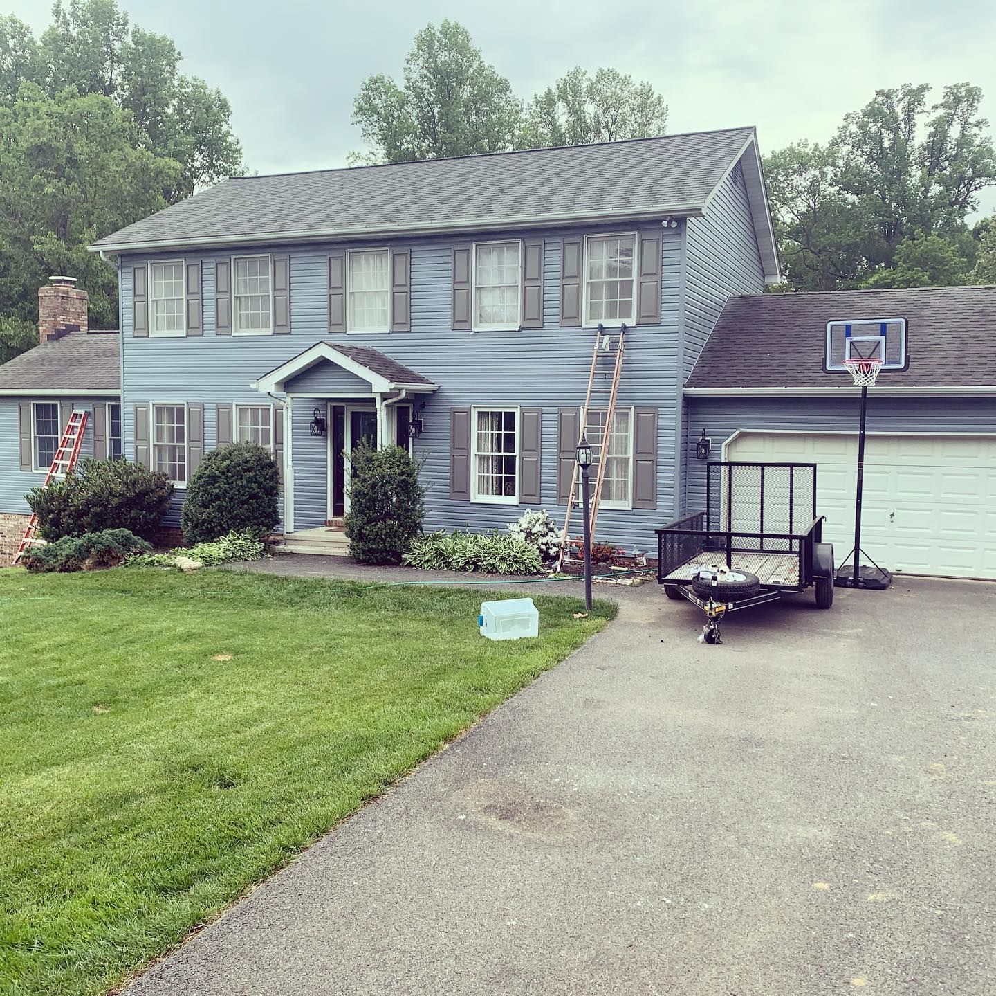 A blue house with a trailer parked in front of it
