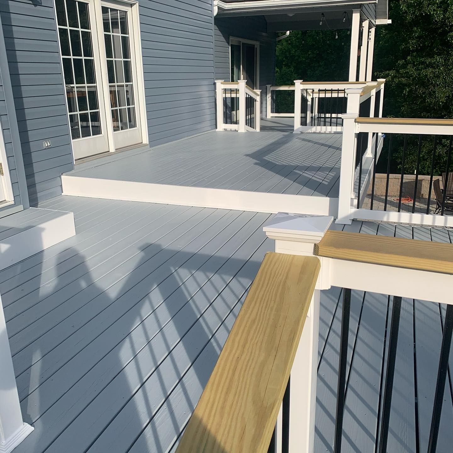A blue house with a white deck and a white railing