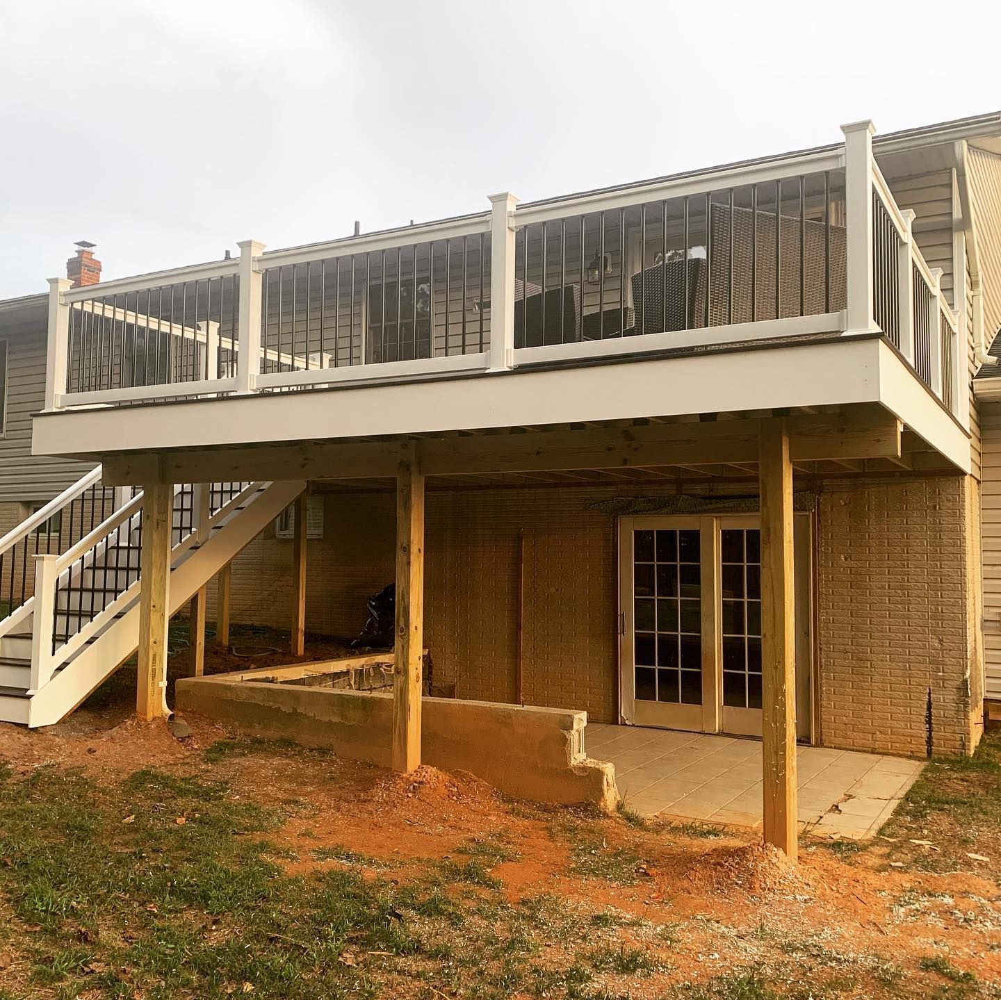 The back of a house with a large deck and stairs.