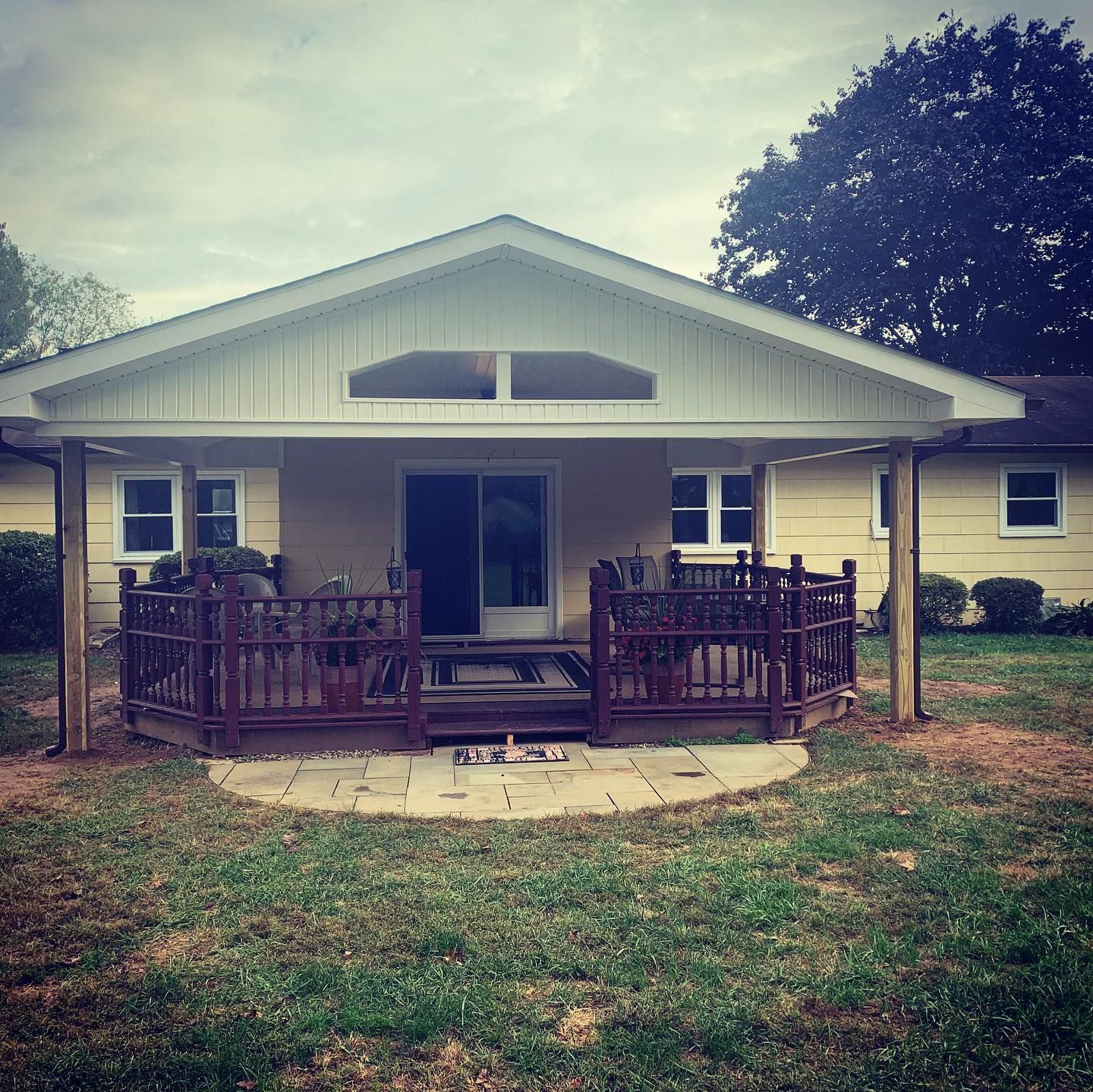 A house with a porch and a fence in front of it