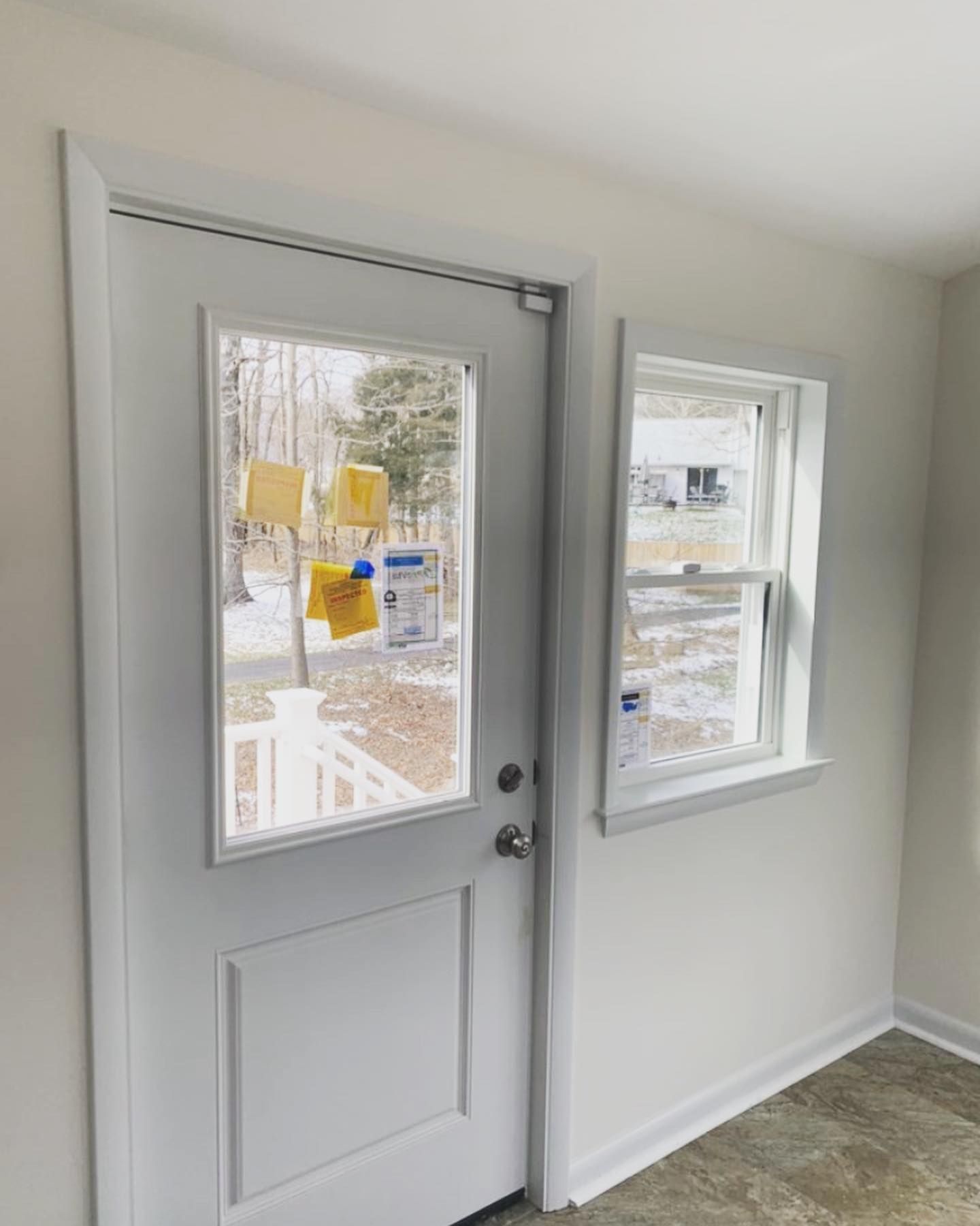 A white door with a window in a room.