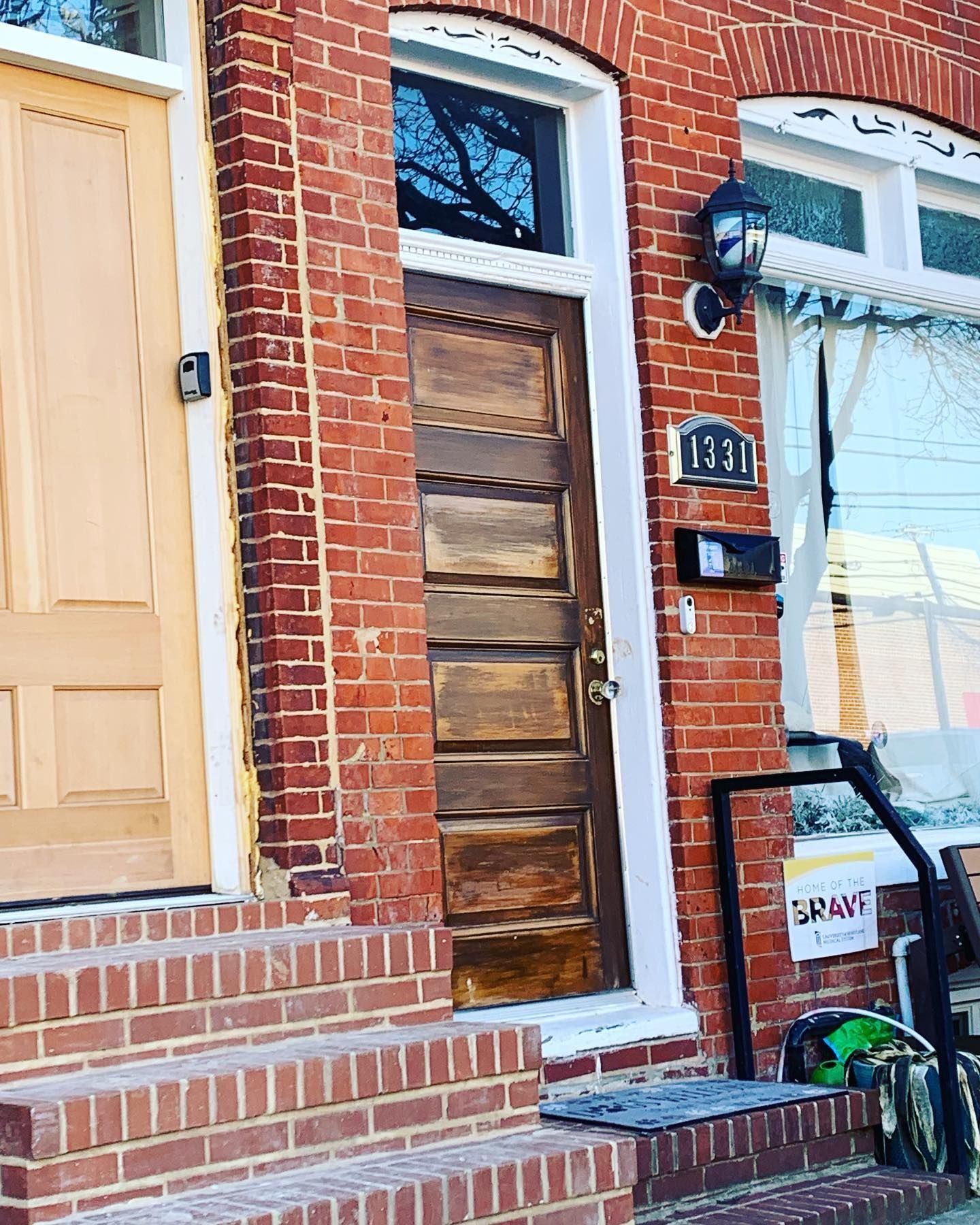 A brick building with a wooden door and stairs