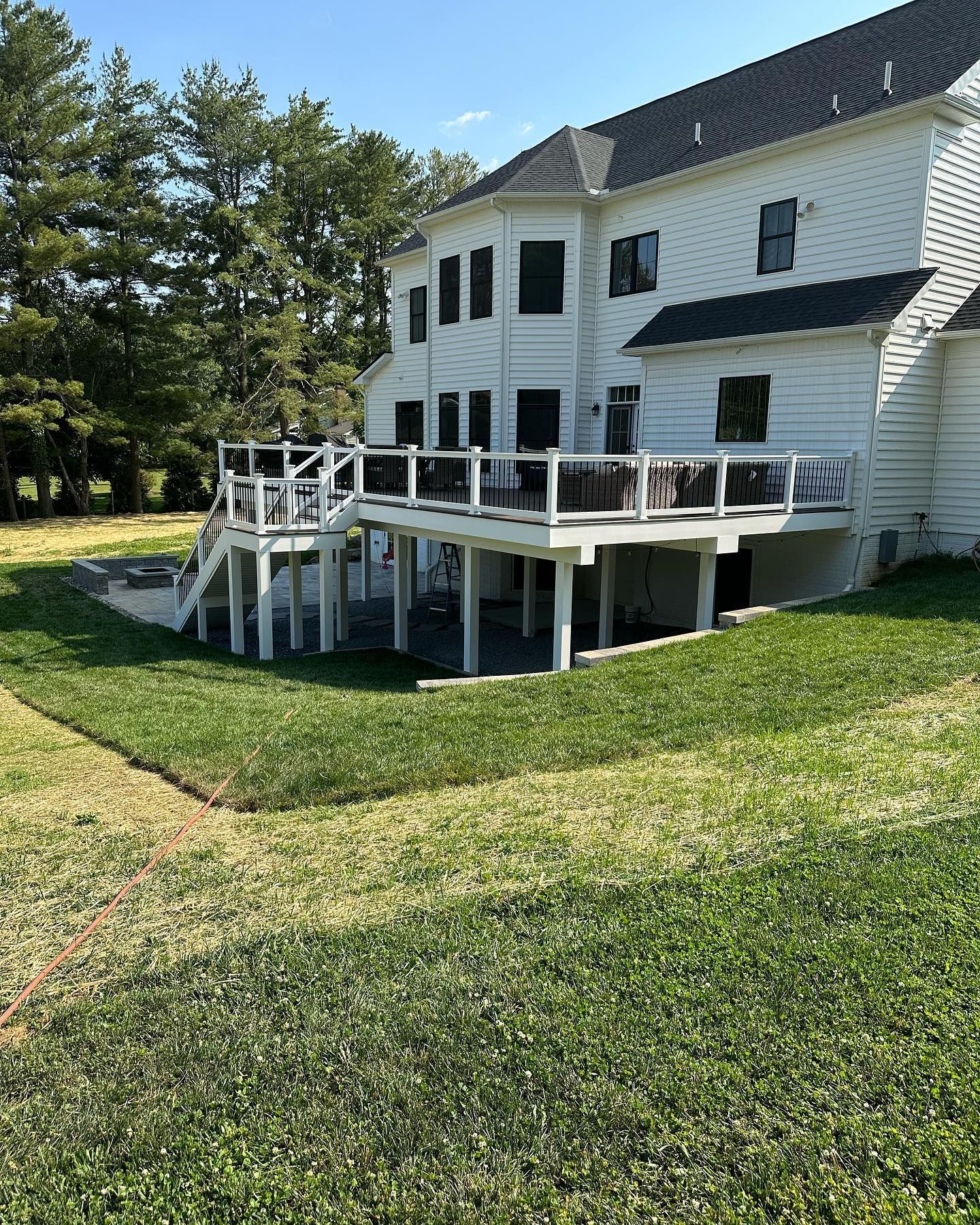 A large white house with a large deck in the backyard.