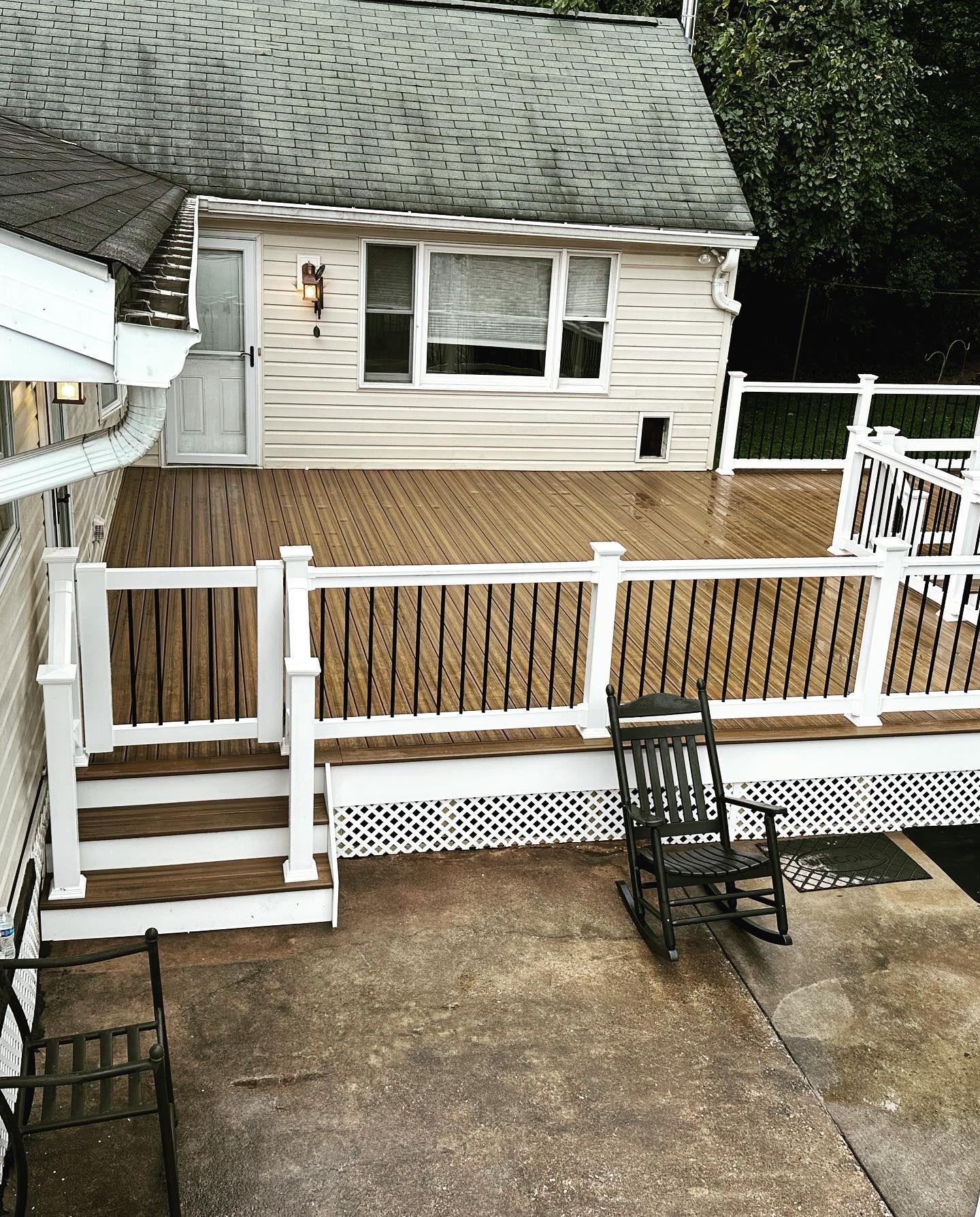 A white house with a wooden deck and rocking chairs