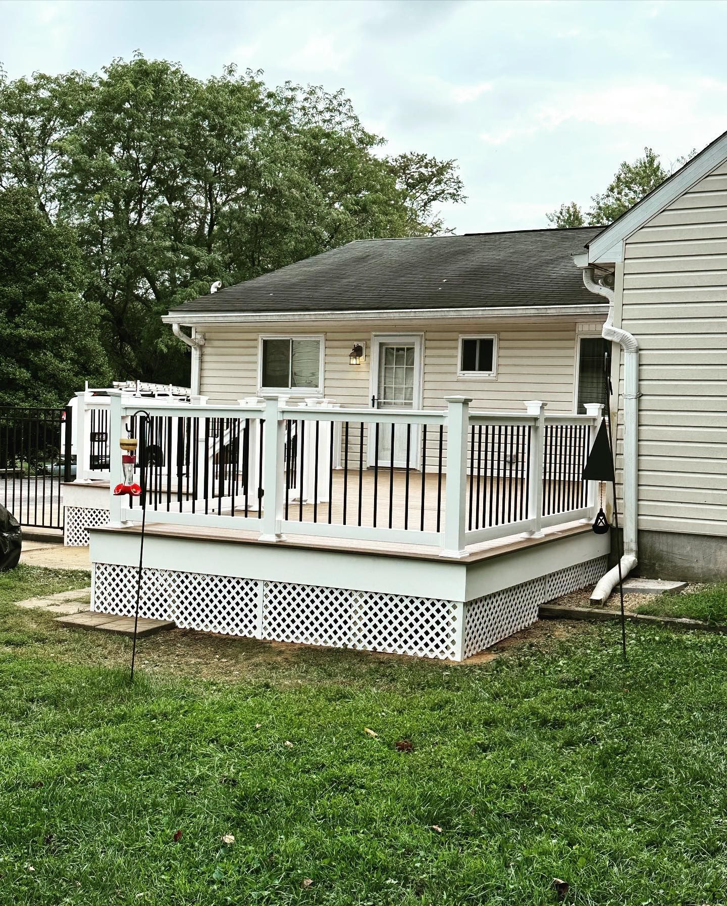 A white house with a large deck in front of it.