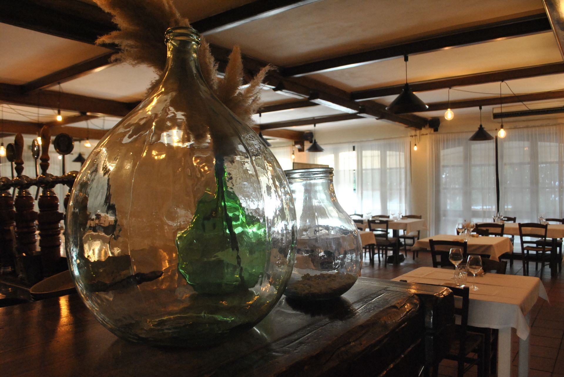 due vasi di vetro sono seduti su un tavolo in un ristorante