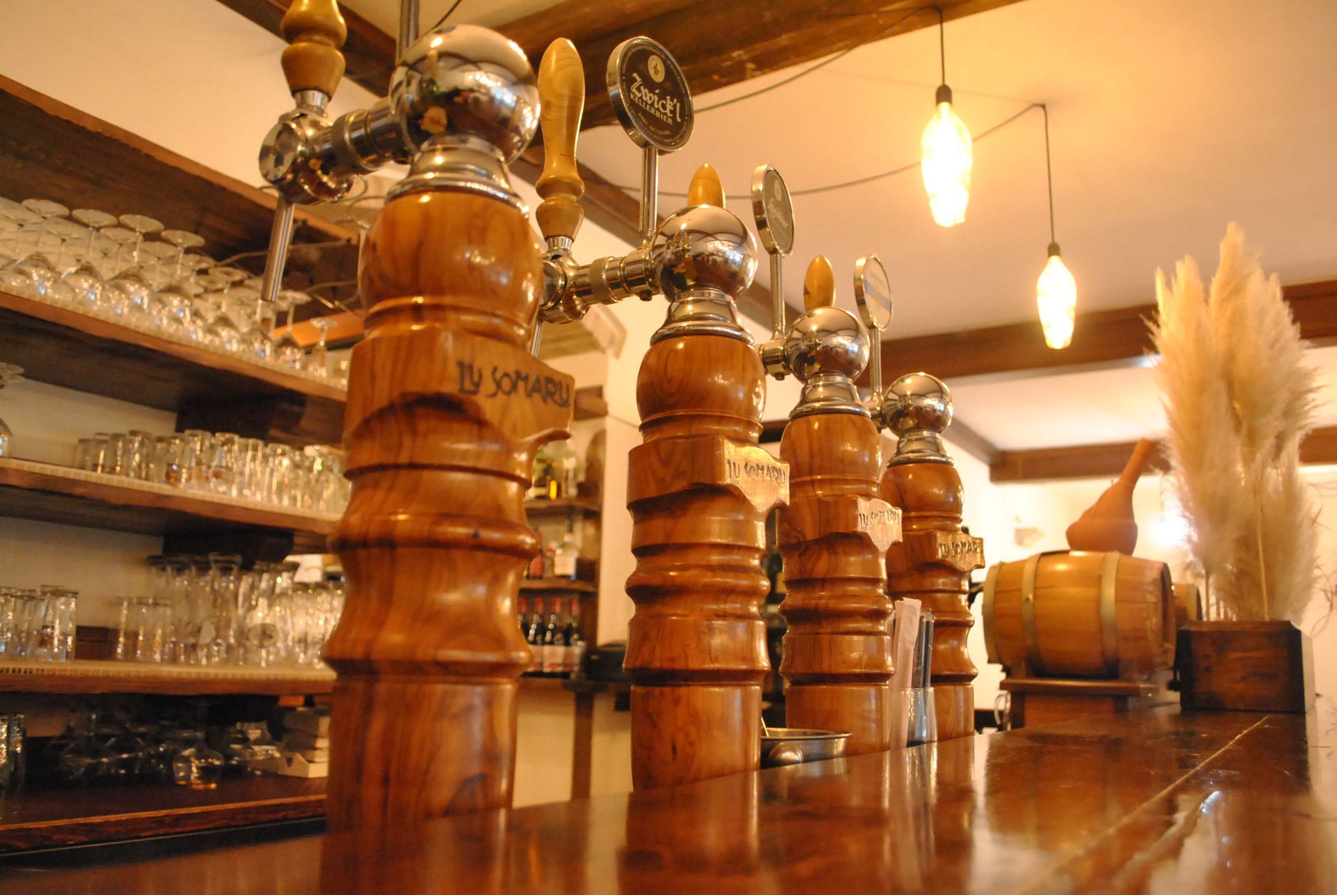 un bar con molti rubinetti in legno e un barilotto