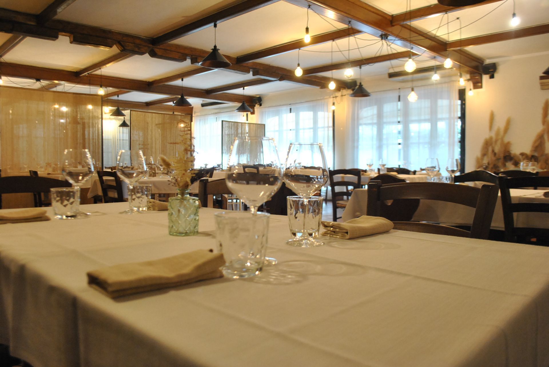 un ristorante pieno di tavoli e sedie e bicchieri di vino