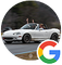 A white Mazda Miata convertible driving on a road with a passenger waving their arms in the air.