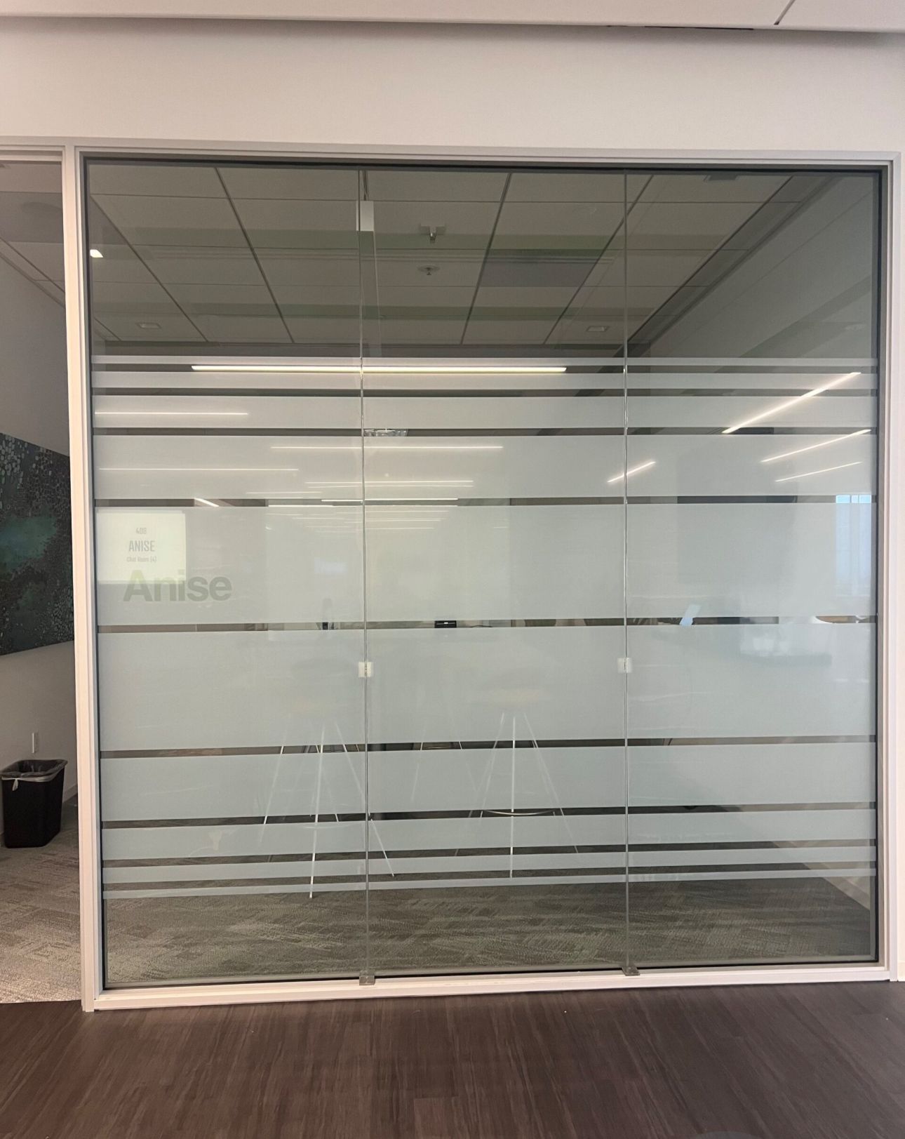Glass office door with frosted horizontal stripes and the word 