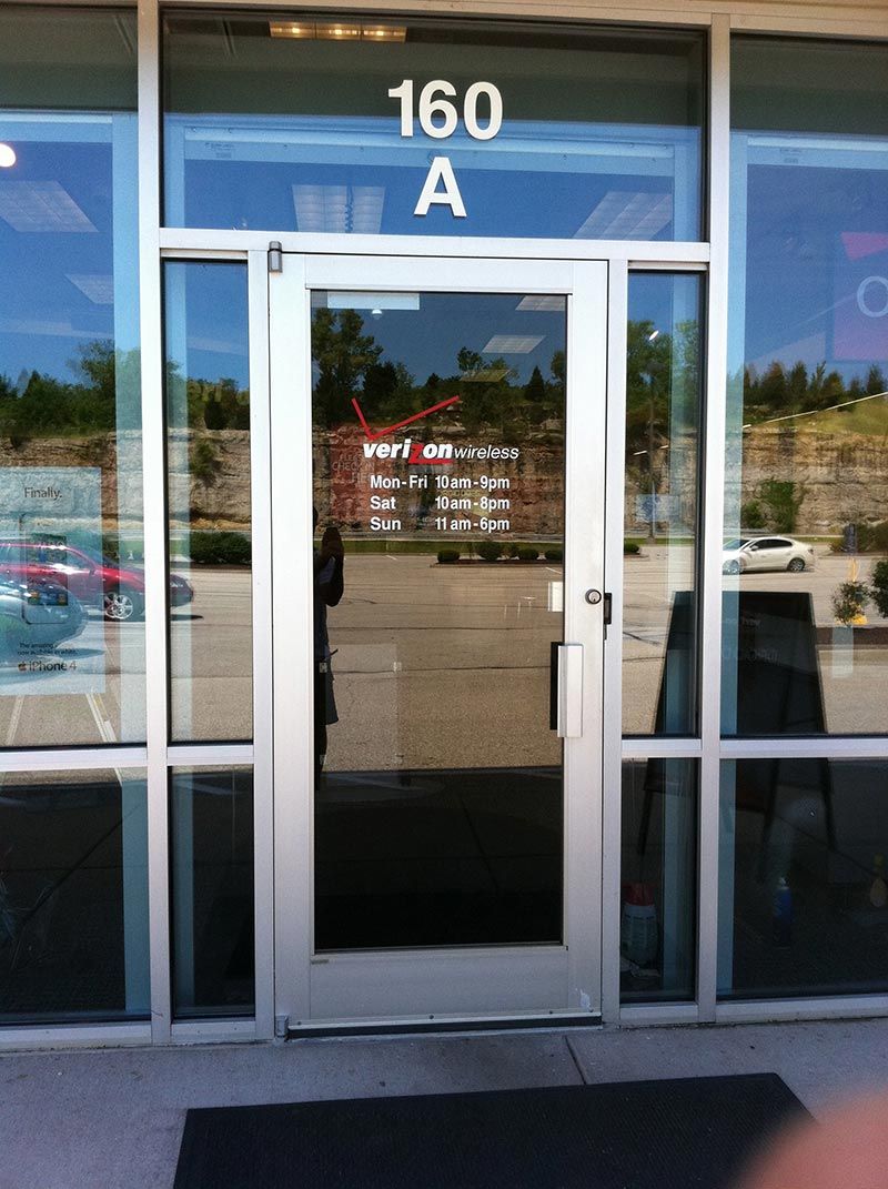Exterior of business with glass door and windows, marked 