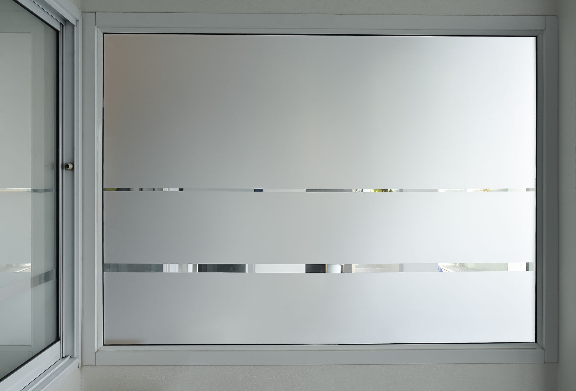 Frosted window with horizontal stripes, providing privacy while still allowing light in.