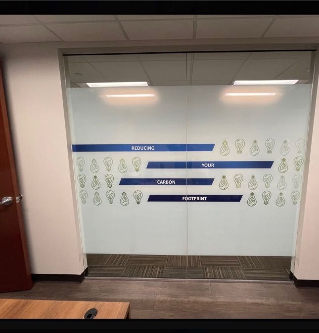 Glass doors with frosted, blue-accented graphic design. Words 