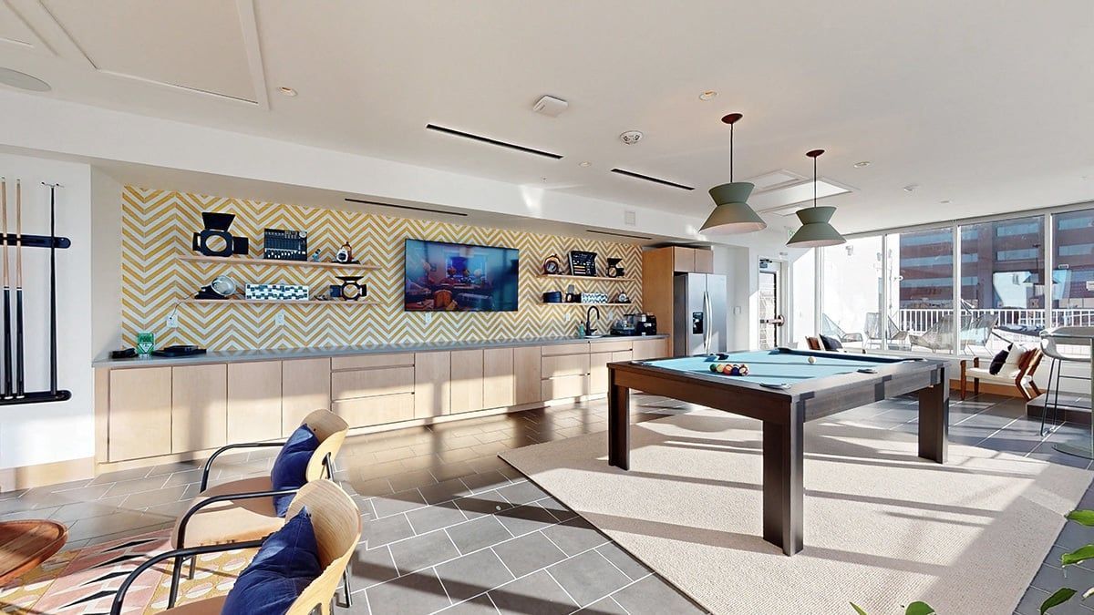 Game room with a pool table, built-in cabinetry, shelves, and seating near a window.