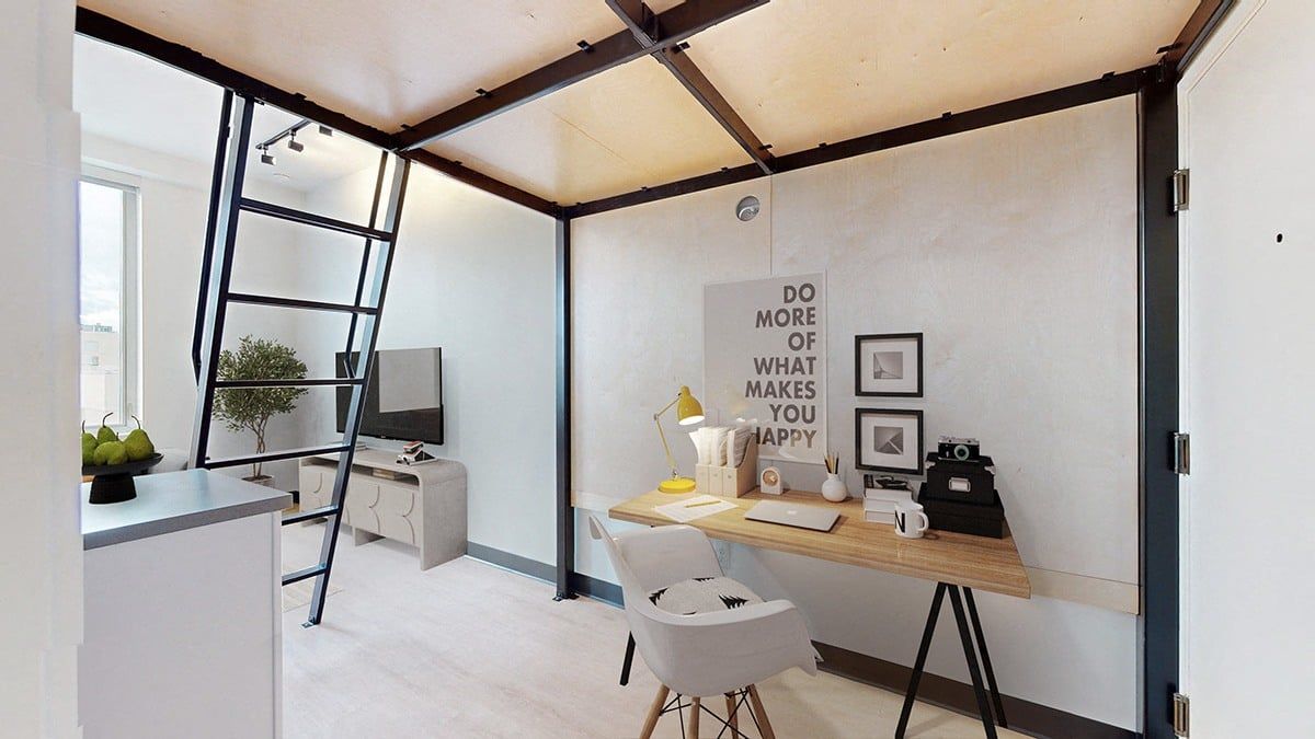 Workspace with desk, chair, ladder, and decorative wall art. White, black, and wood tones are prominent.