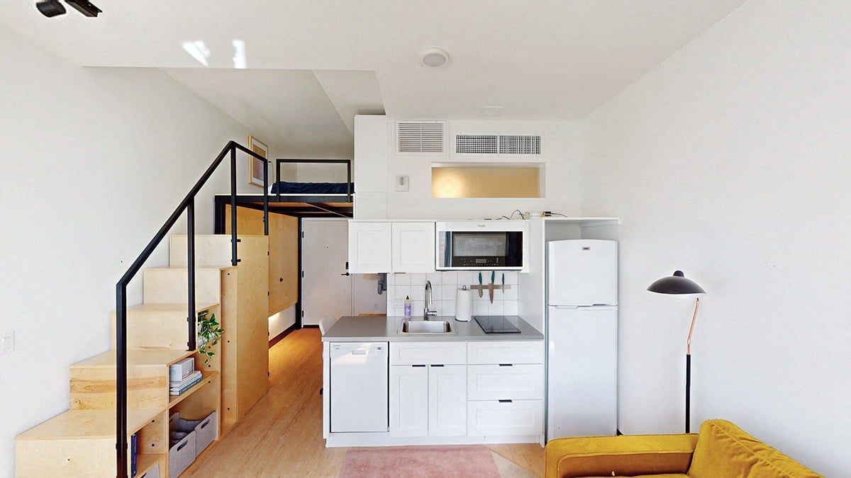 A kitchen with white cabinets and a white fridge.