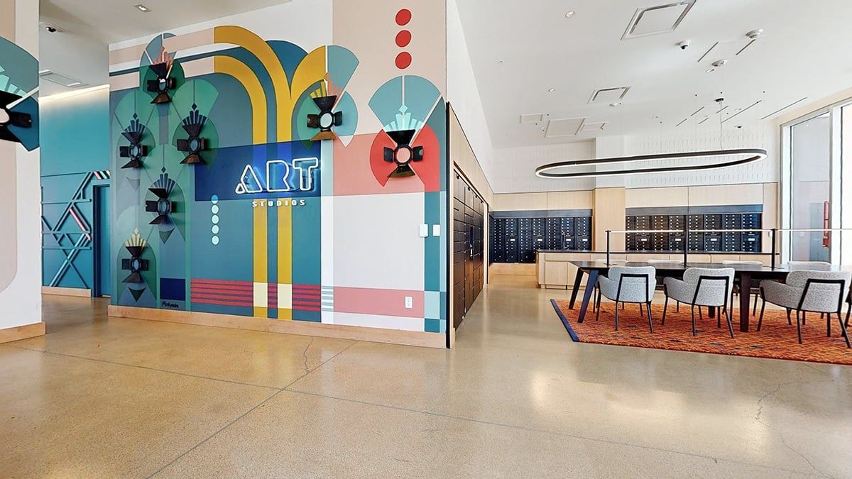 Colorful modern office interior with abstract wall art and dining area.