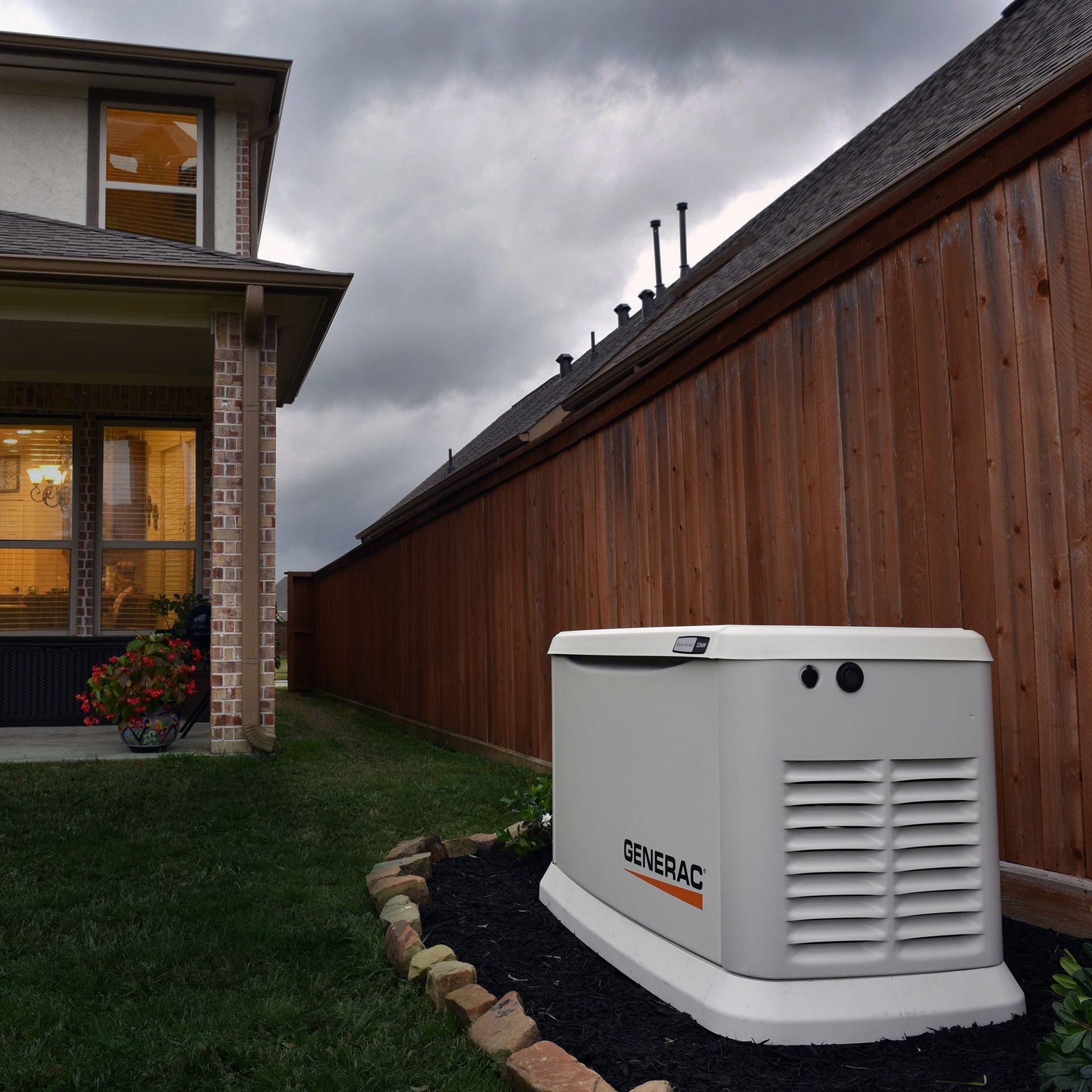 A generator is sitting in the grass in front of a house