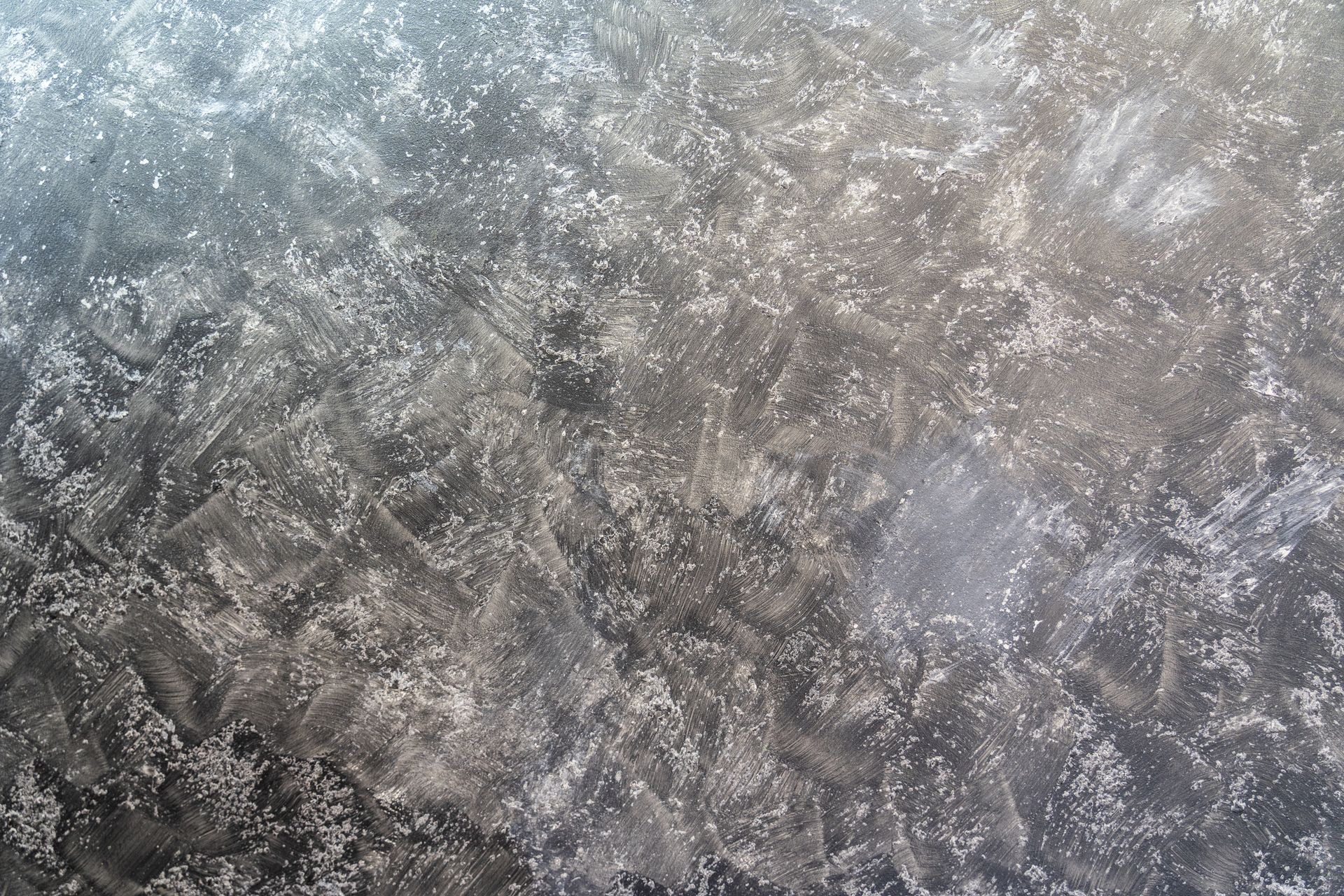 Textured surface of dark gray and white paint, resembling frost or ice crystals.