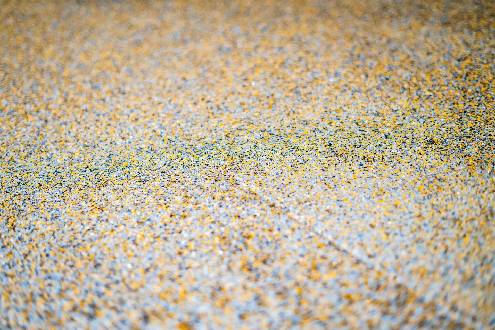 Close-up view of a floor surface covered in tiny, multi-colored granules.