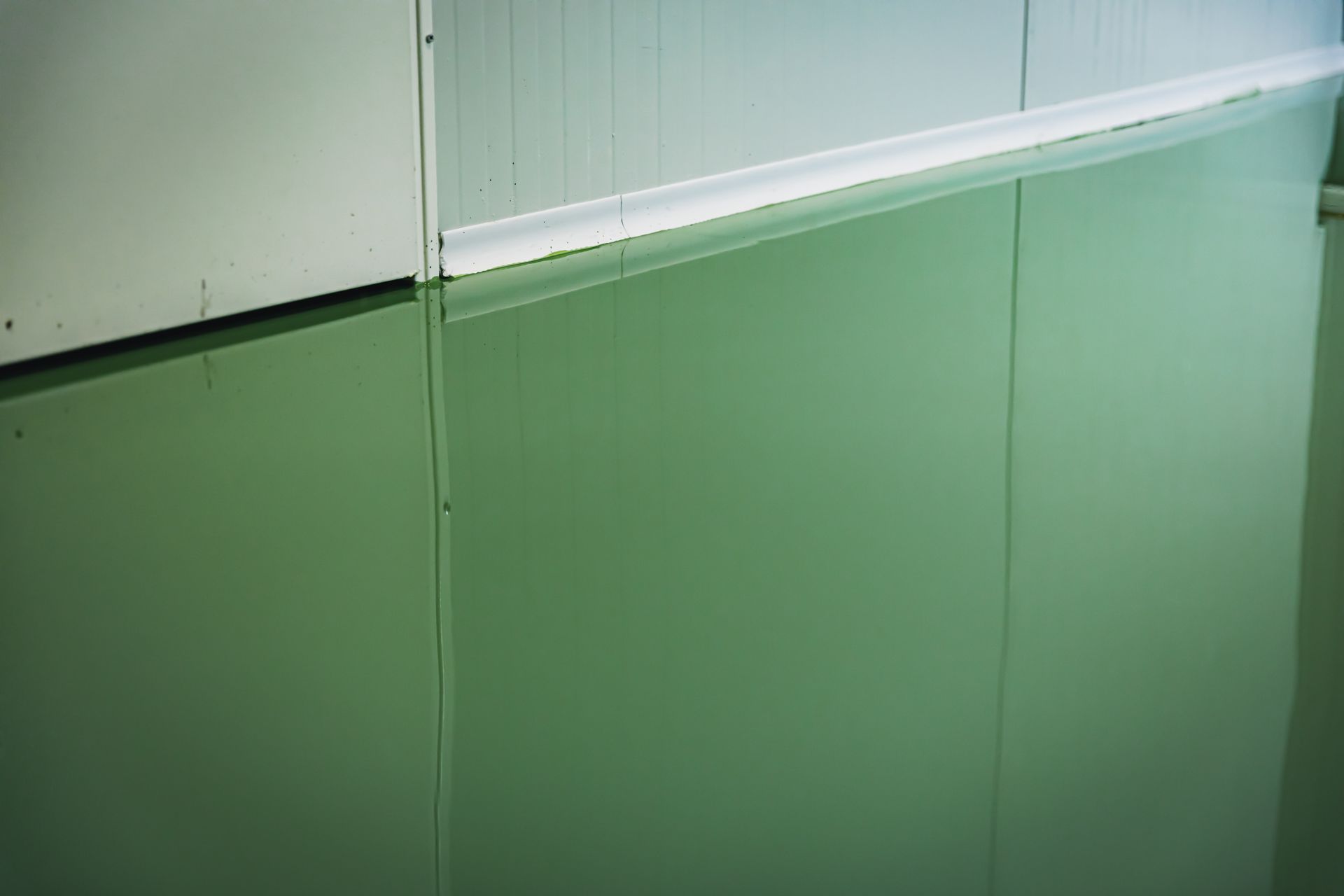 Green and white wall panels with a metal trim.