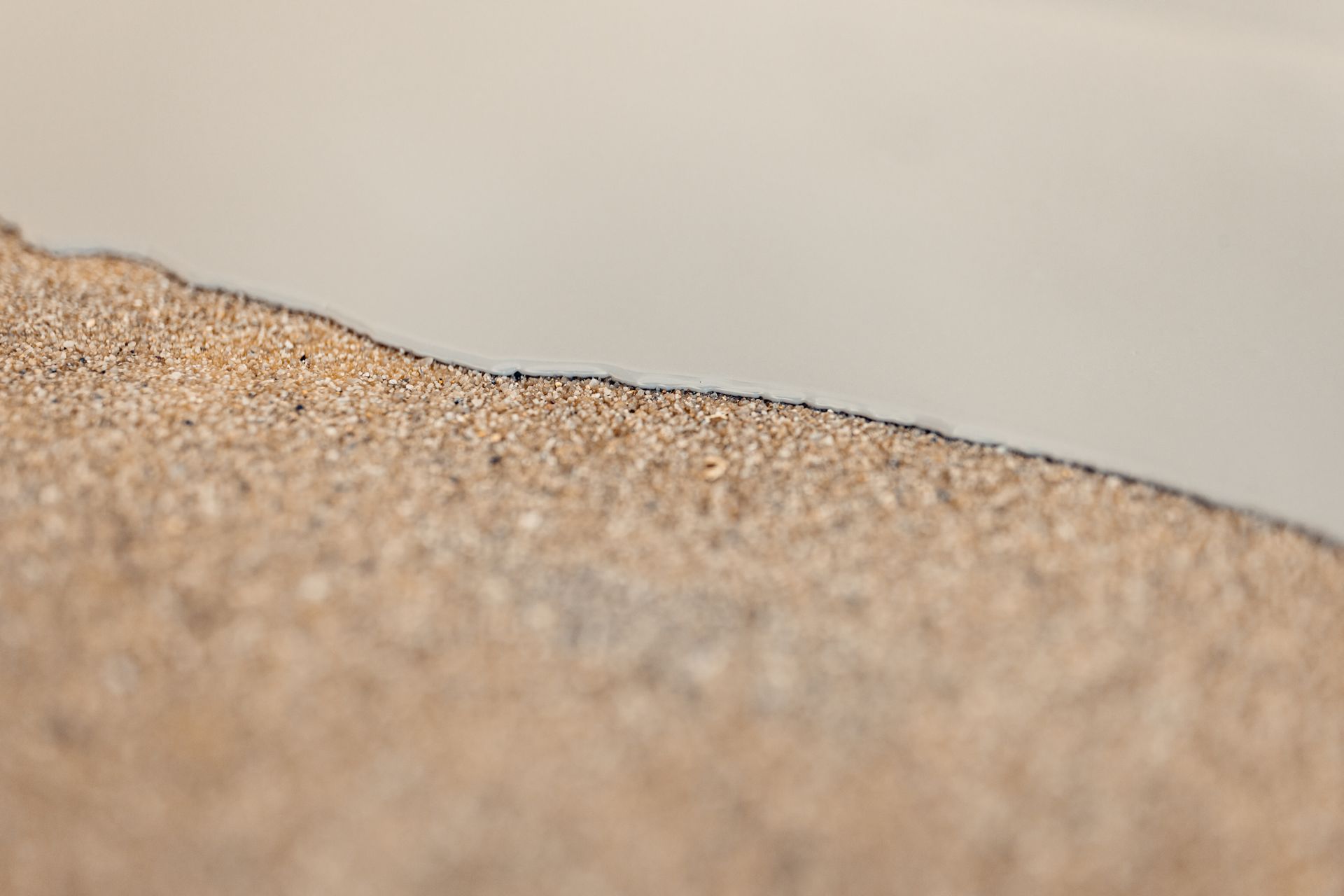 Sandy, textured surface meets a smooth, light gray surface.