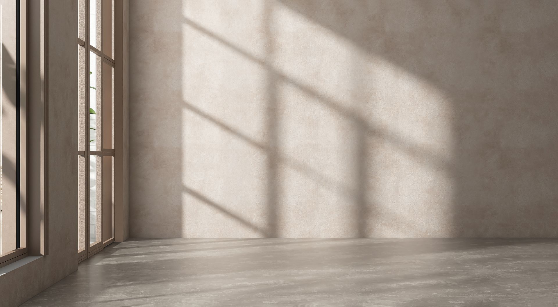 Empty room with window on the left casting shadows onto a textured beige wall and floor.