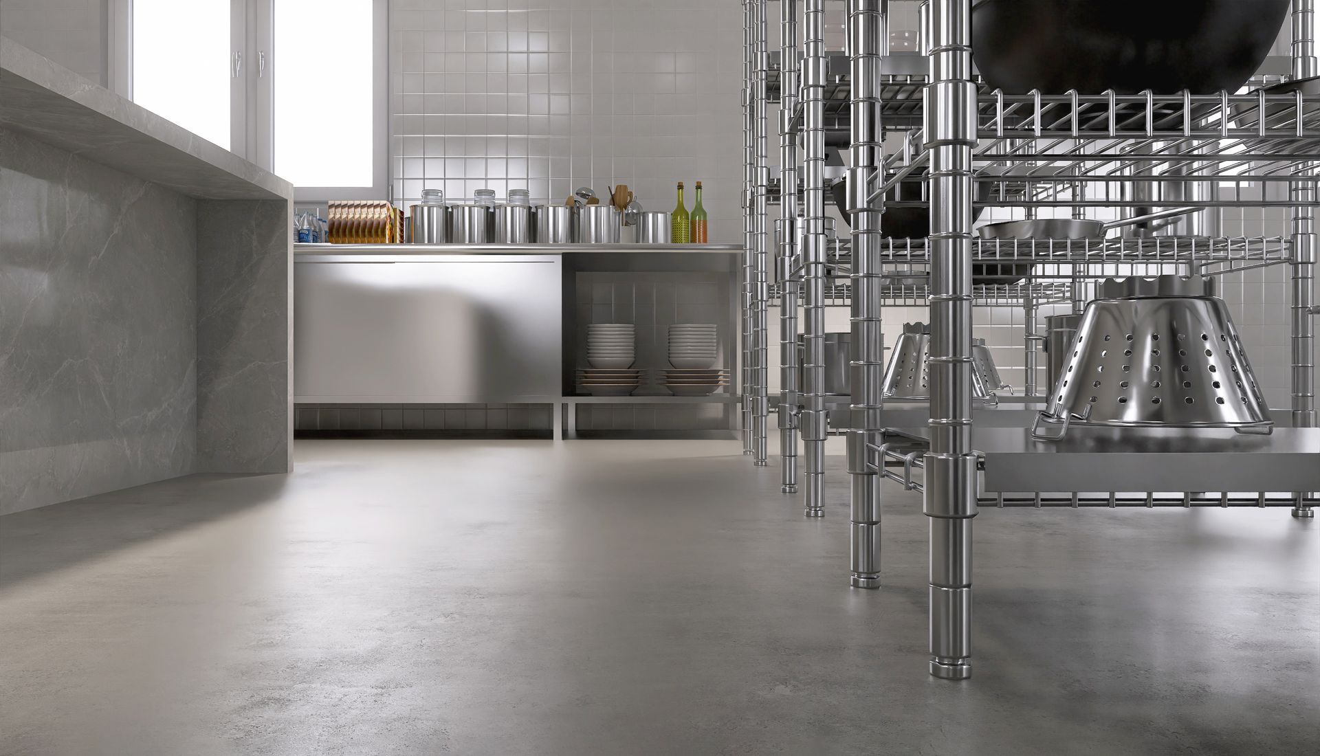 Commercial kitchen with stainless steel shelves, appliances, and a polished concrete floor.
