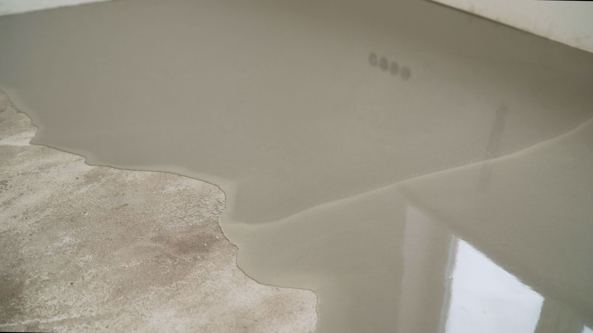 Gray liquid pooling on a light-colored concrete surface.
