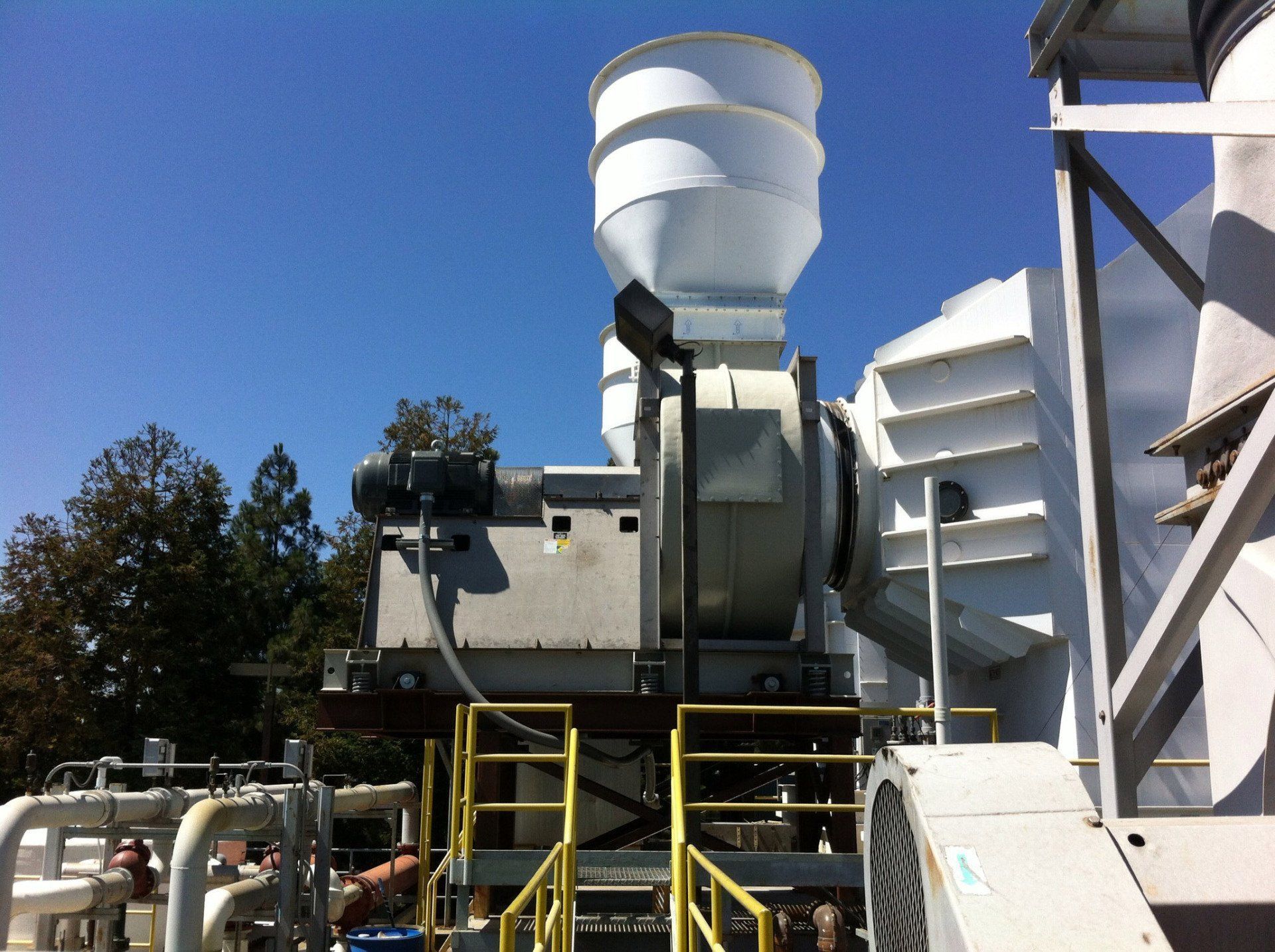 Industrial machinery with a white funnel, set against a blue sky.