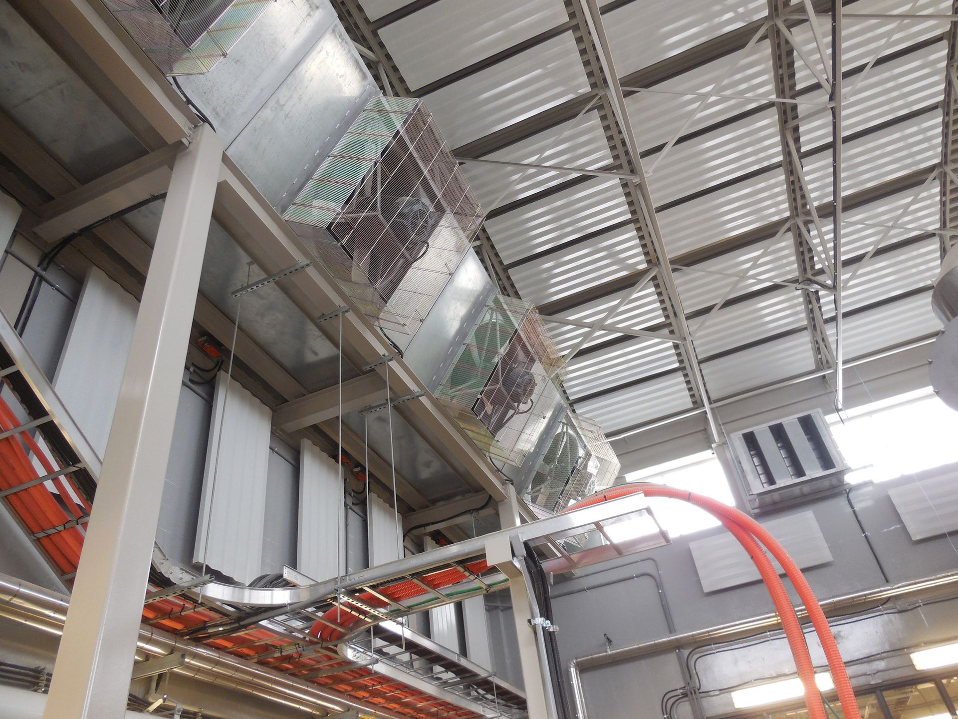 HVAC ductwork and pipes installed on the ceiling of an industrial building.