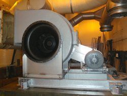 Metal industrial fan with motor, ductwork, and enclosure.