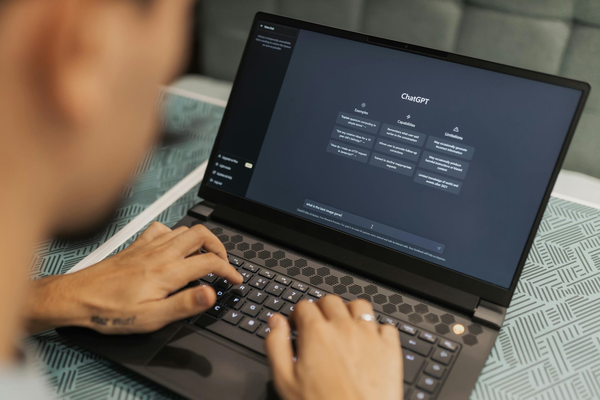 Person typing on a laptop with a dark login screen in a dim room