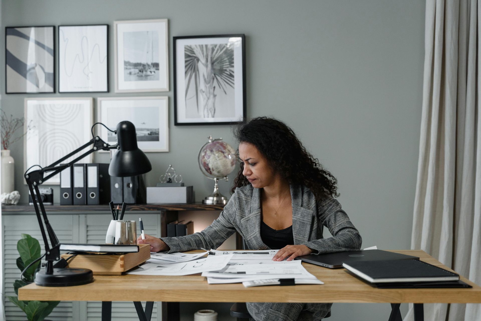 A woman is sitting at a desk in an office working on a project.
