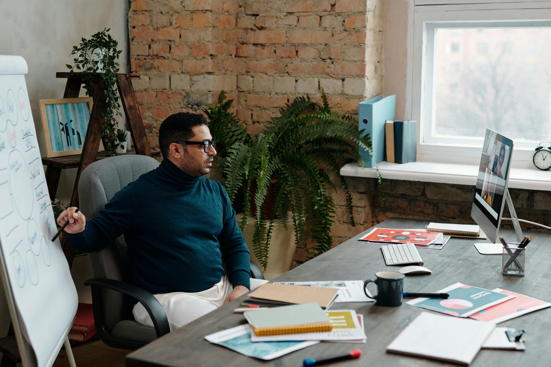 A man is sitting at a desk in front of a computer.