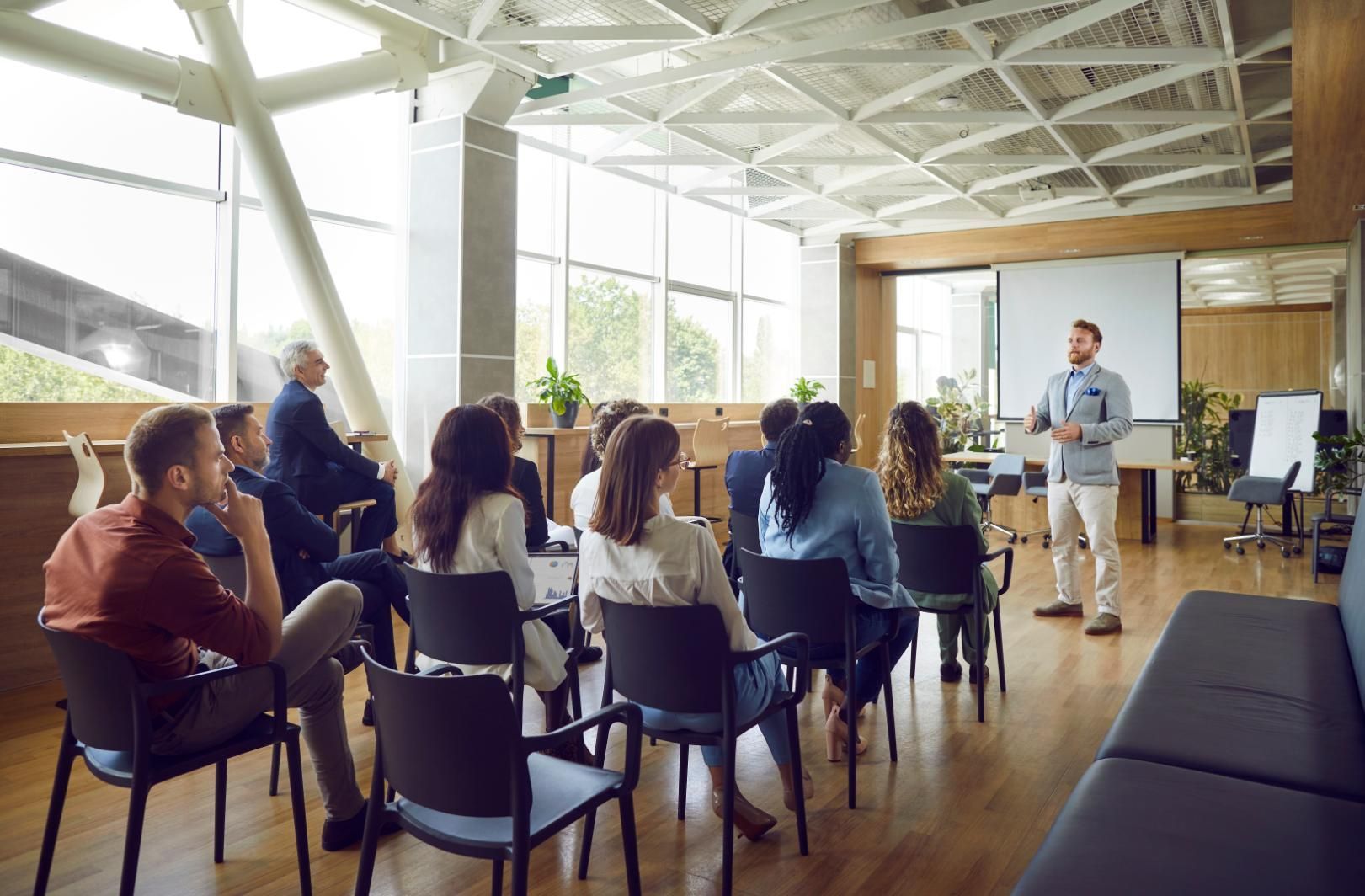 A man is giving a presentation to a group of people in a conference room.
