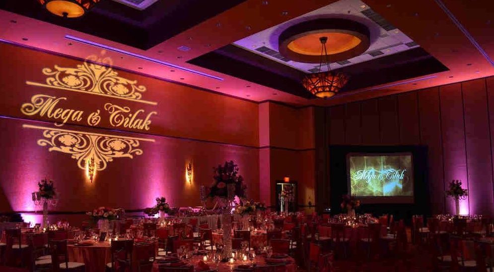 A large room filled with tables and chairs with a sign on the wall that says `` mega & galak ''.