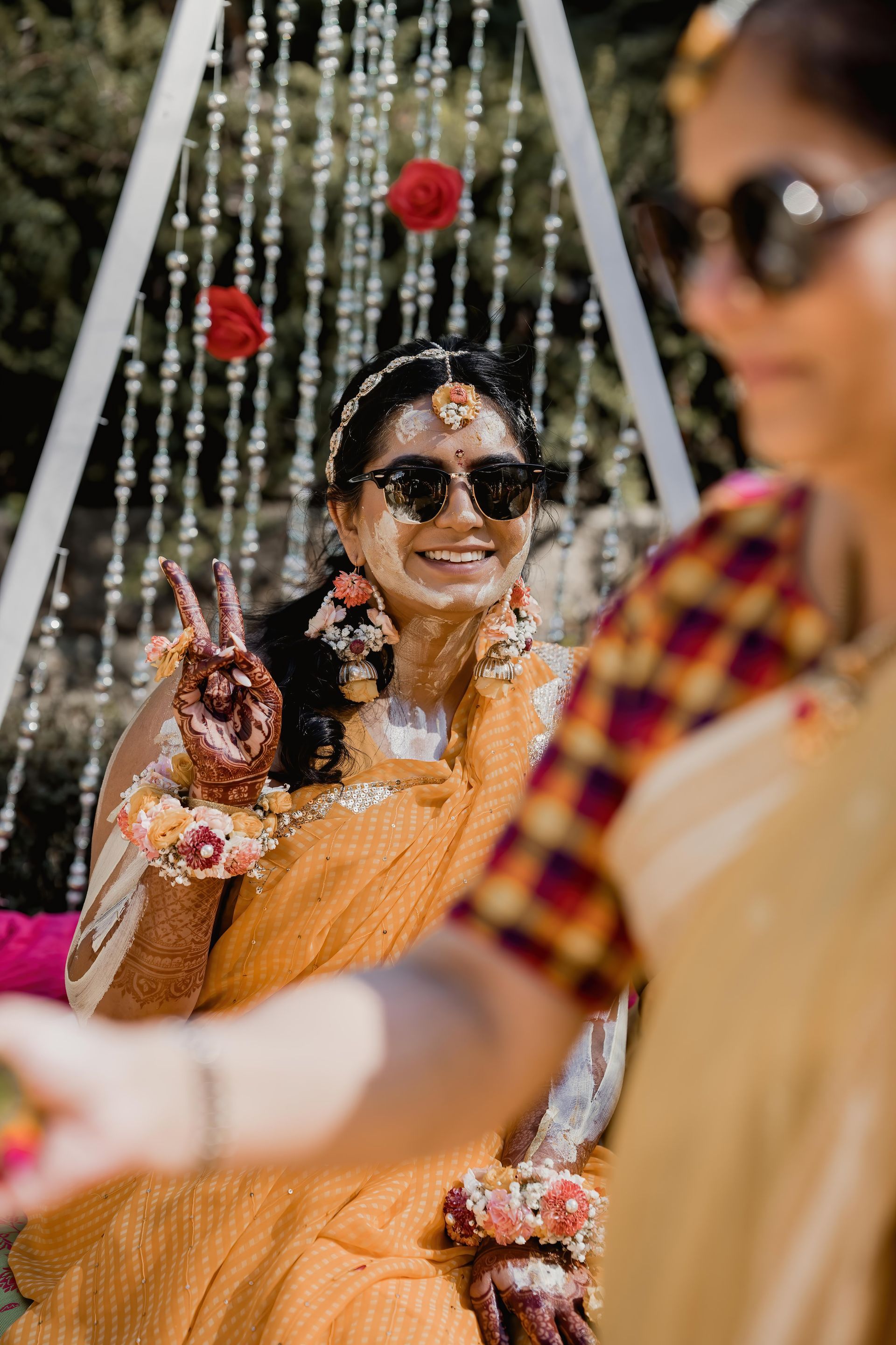 A woman in a yellow dress is sitting on a swing.