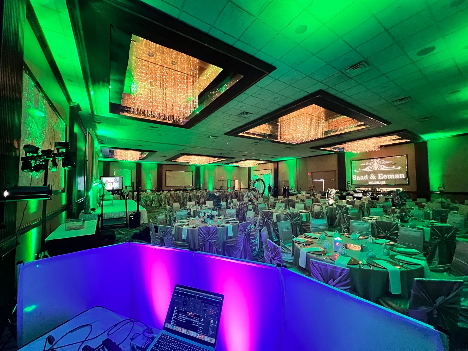 A large room with tables and chairs and a laptop on a table.