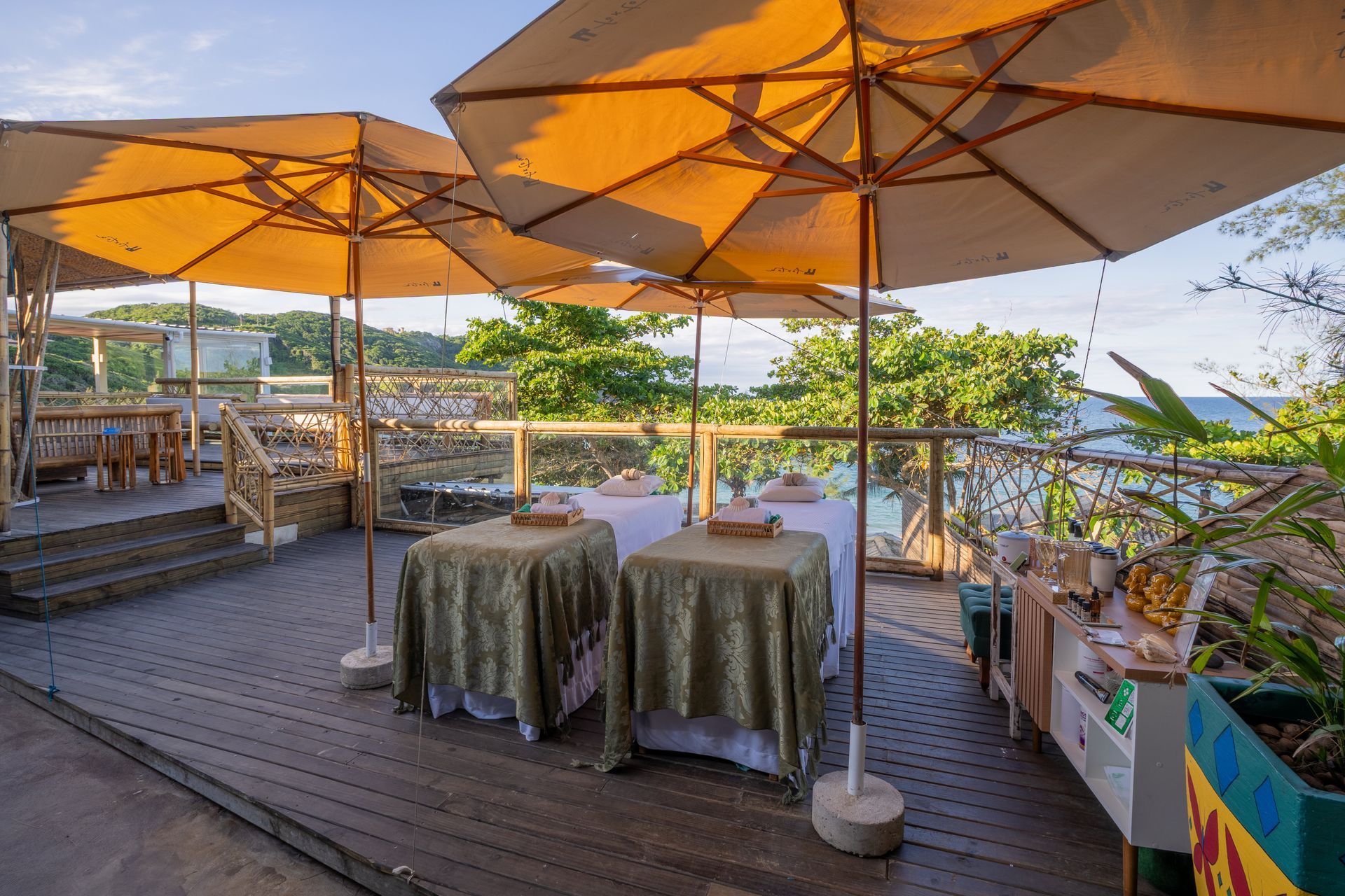 Piscina e pérgola branca com vista para o oceano azul. Uma estátua de Buda fica junto à piscina.
