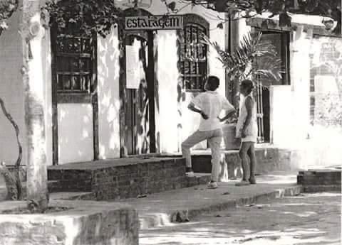 Two people stand outside a building with the word "ESTANCIA" visible.