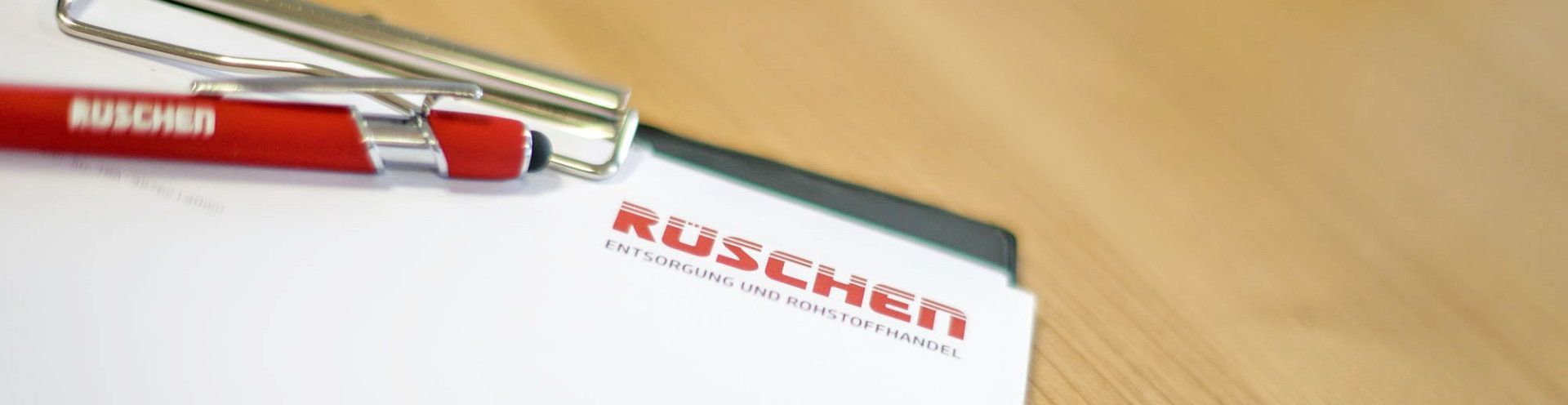 Auf einem Klemmbrett liegt ein roter Stift.