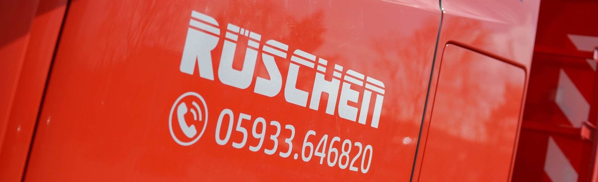 Ein roter LKW mit dem Wort „Rüschen“ darauf