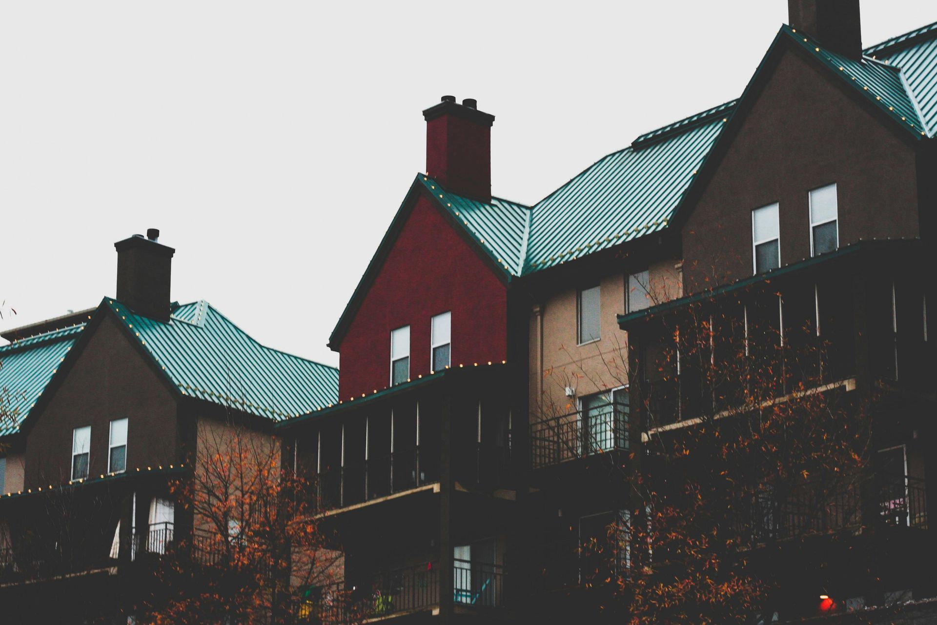 A row of houses with green roofs and chimneys