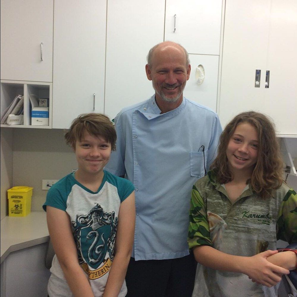 A Man And Two Girls Pose For A Picture In A Kitchen — BB Dental Cairns Dentists Dental In Earlville, QLD