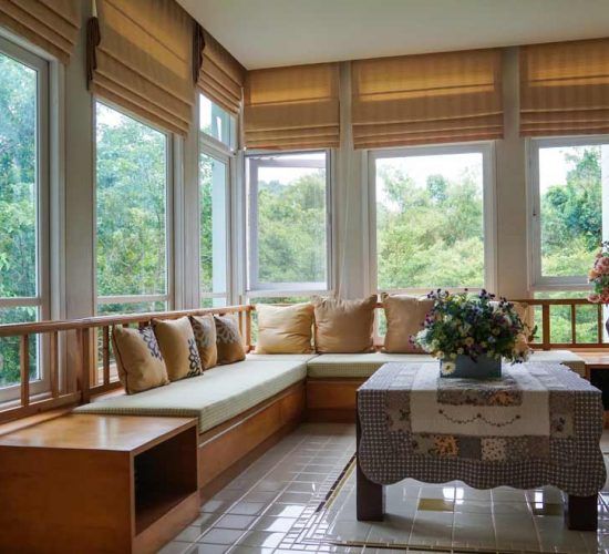 A Gray and White Striped Roman Shade Is Hanging on A Window — Bay Blinds & Doors in Woongarrah, NSW