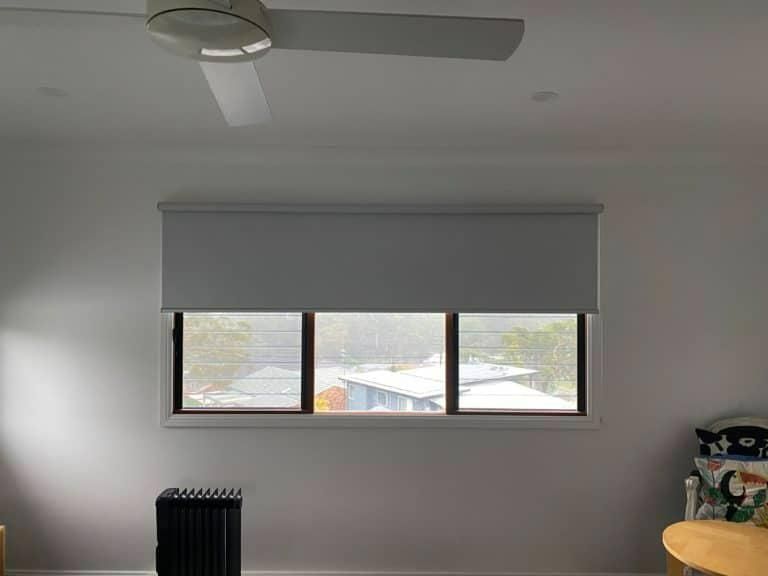 A Couch with Pillows on It Is on A Balcony with Shutters — Bay Blinds & Doors in Morriset, NSW