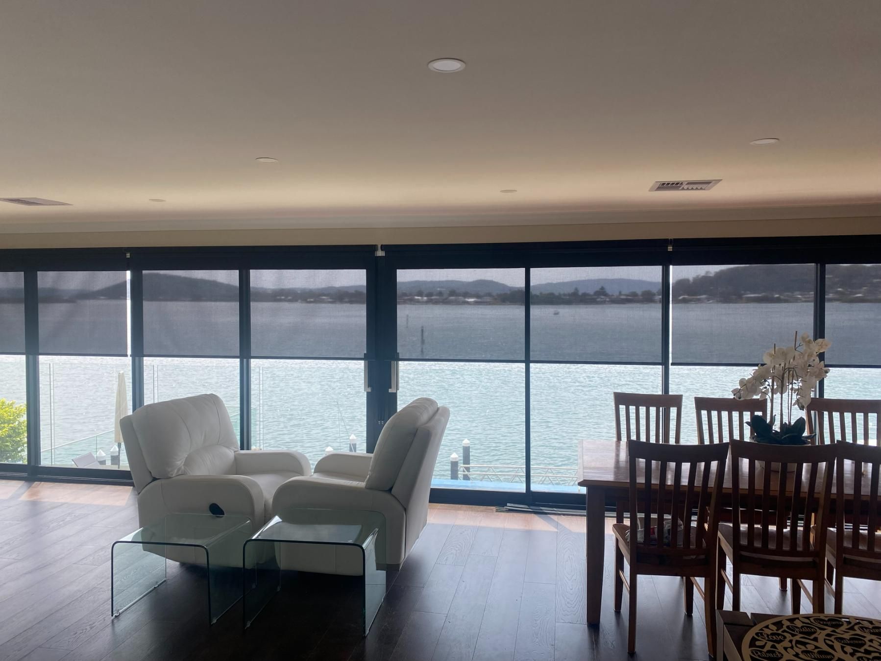 A Living Room and Dining Room with A View of The Water — Bay Blinds & Doors in Bateau Bay, NSW