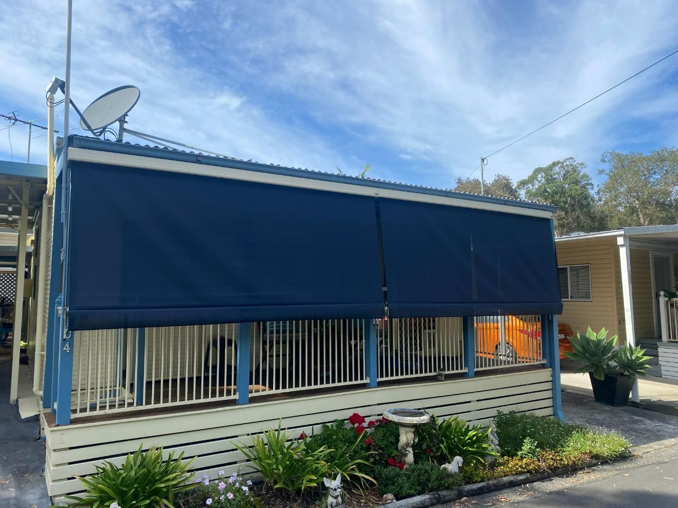 A Mobile Home with A Blue Awning on The Side of It — Bay Blinds & Doors in Bateau Bay, NSW